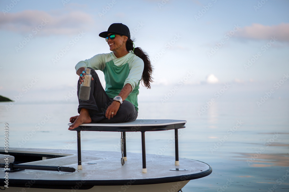 Woman sitting on motorboat with bottle Woman sitting on motorboat with bottle