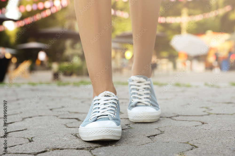Woman in stylish shoes walking on city street, closeup