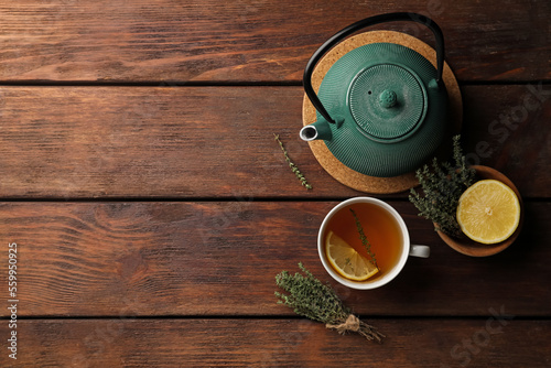 Obraz na plátně Aromatic herbal tea with thyme and lemon on wooden table, flat lay