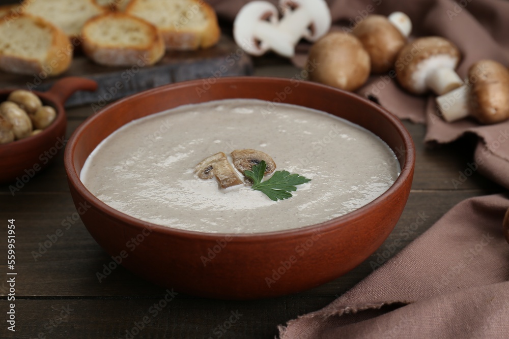 Delicious mushroom cream soup with parsley on wooden table Delicious mushroom cream soup with parsley on wooden table