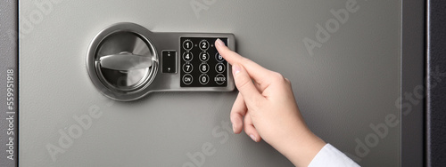 Obraz na płótnie Woman opening steel safe with electronic lock, closeup
