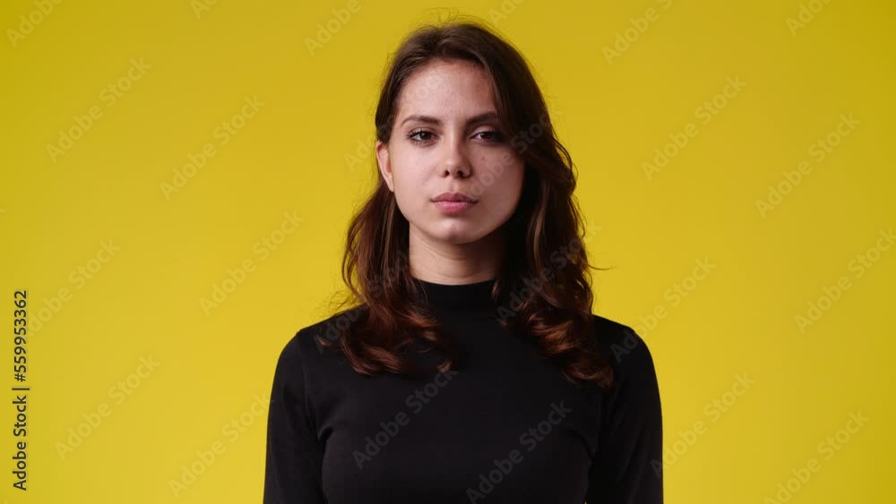 4k video of blank emotion of one girl on yellow background.