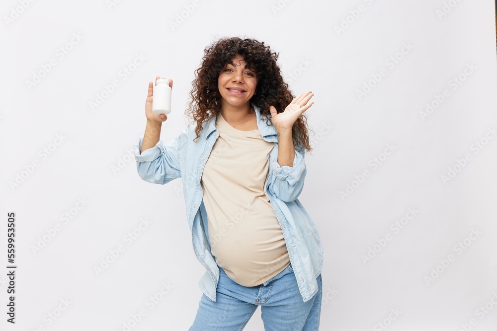 Pregnant woman smile with teeth jar of pregnancy vitamin pills in hands, alpha lipoic acid, vitamin complex on white isolated background copy space Pregnant woman smile with teeth jar of pregnancy vitamin pills in hands, alpha lipoic acid, vitamin complex on white isolated background copy space