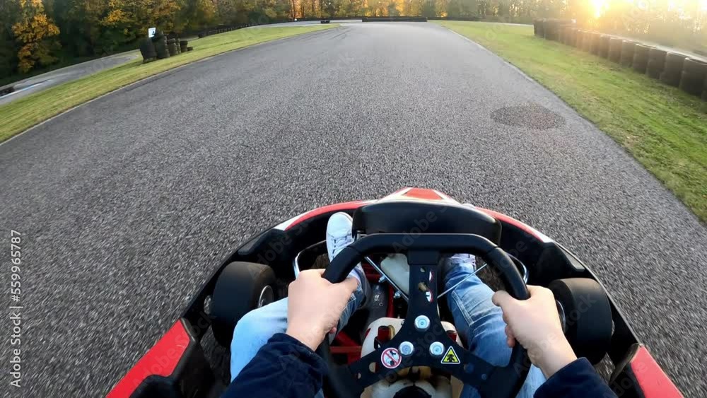 Riding a go kart at sunset point of view on race track