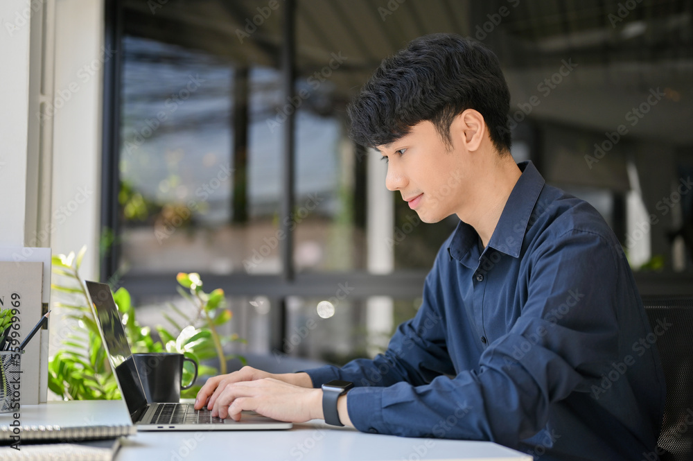 Professional Asian businessman using laptop, typing on notebook keyboard at his office desk. Professional Asian businessman using laptop, typing on notebook keyboard at his office desk.
