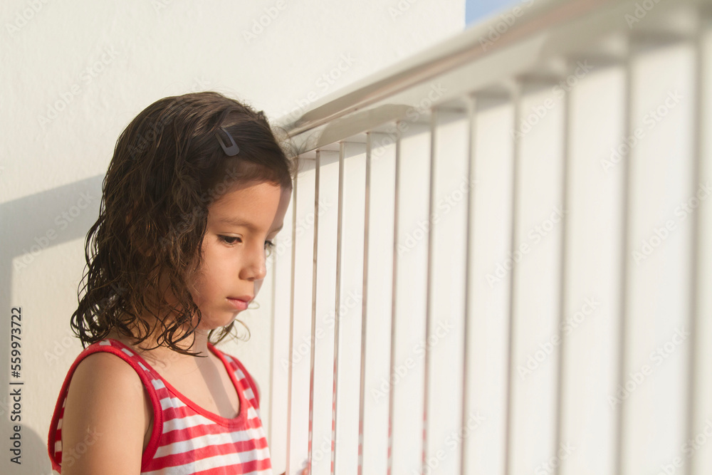 Sad little child watching by a fense, child abuse concept Sad little child watching by a fense, child abuse concept