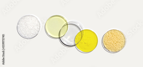 Microcrystalline wax, Poly Aluminium chloride liquid, Potassium Chromate and Candelilla wax in Petri dish on white laboratory table. Chemical ingredient for Cosmetic and Toiletries product. Top View