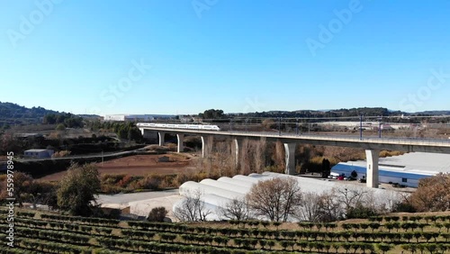 Aerial: high-speed train crossing a viaduct in Spain, between Barcelona and Madrid. Catalonia.