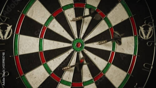 A dart being thrown at a dart board and a hand grabbing the dart photo