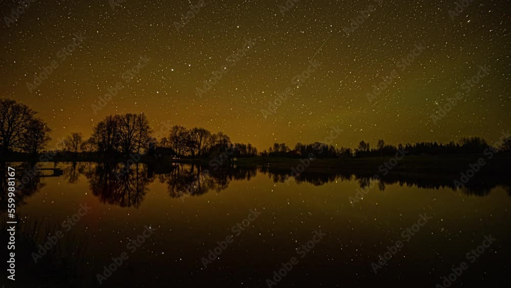 Starry night time lapse with the sky reflecting on the surface of a lake Starry night time lapse with the sky reflecting on the surface of a lake