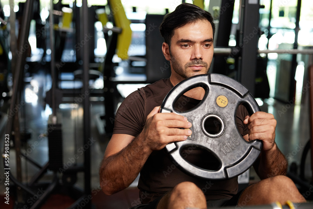 young athletic man exercise with weight lifting rubber plates in the gym young athletic man exercise with weight lifting rubber plates in the gym