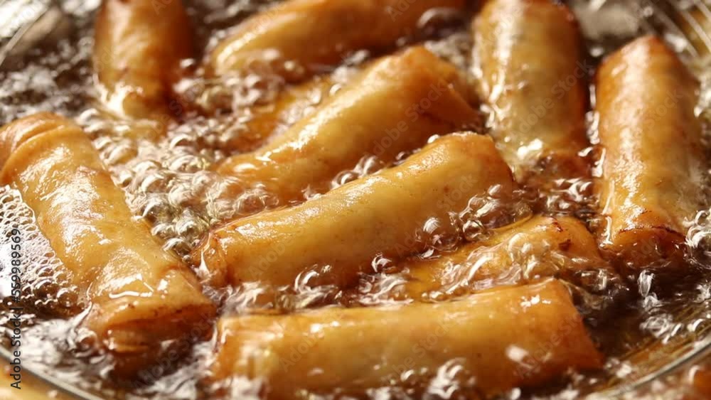Close up of deep frying spring roll in boiling oil, Chinese food