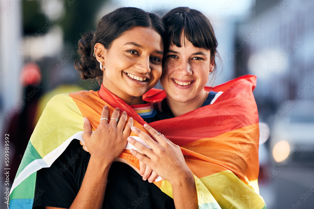Obraz premium Women, lgbtq and portrait with pride flag for love, equality and support in city. Gay, lesbian and couple of friends hug with rainbow identity, happy face and freedom at human rights parade event