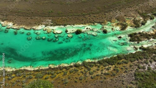 Aerial view of vibrant water and stromatolites formations, at the Rapidos de Bacalar in Mexico - tracking, drone shot photo