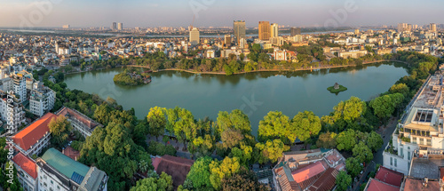 Hanoi, Vietnam - May 04, 2022: Top view aerial photo from flying drone of Hoan Kiem lake, Hanoi City with development buildings, transportation, energy power infrastructure. 