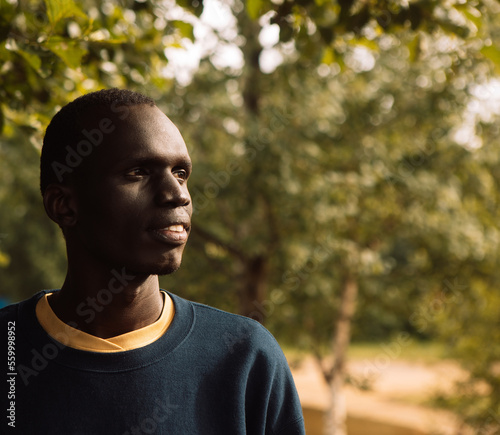 Young African man outdoor, confident and serious student portrait, copy space.