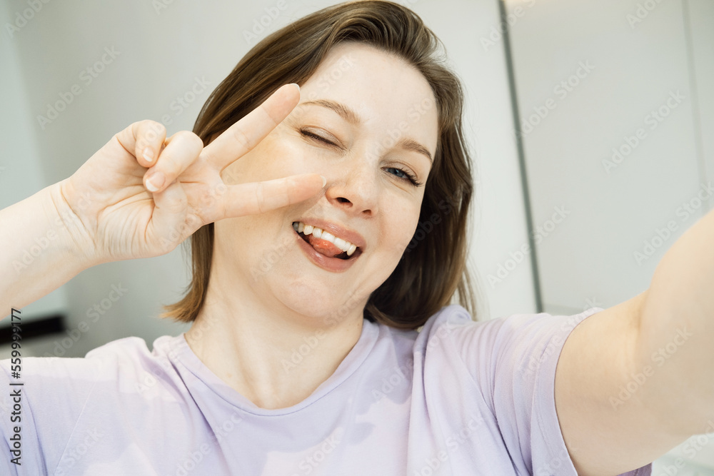 Good mood woman with expansive smile taking selfie on mobile phone at home Good mood woman with expansive smile taking selfie on mobile phone at home