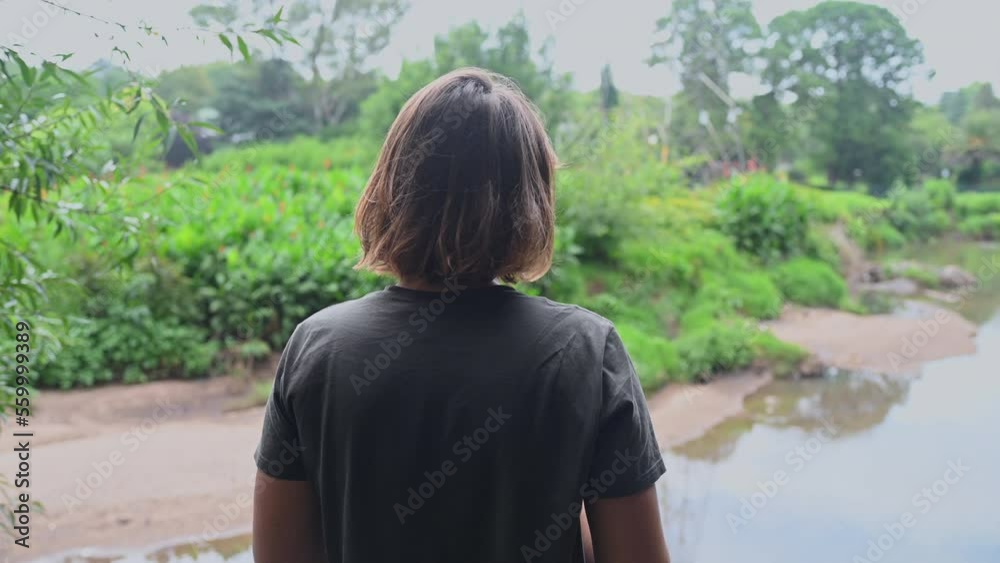 Rear view of woman standing and watching river