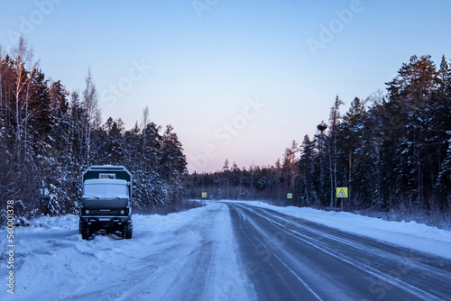 A frozen truck stands on the side of a winter highway in Siberia.
