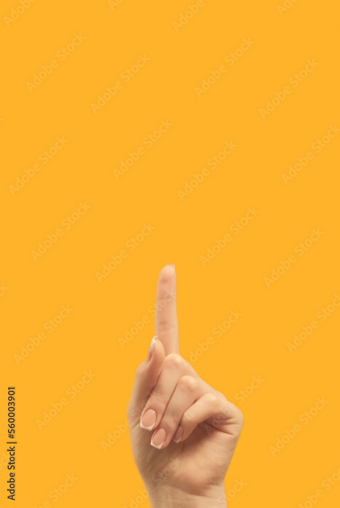 Advertising gesture. Attention idea. Information announcement. Female hand finger pointing up at bright orange copy space commercial background.
