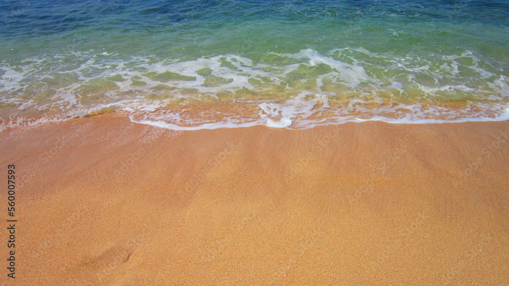Obraz premium Golden sand beach and soft waves of the ocean. Beautiful background of summer day.