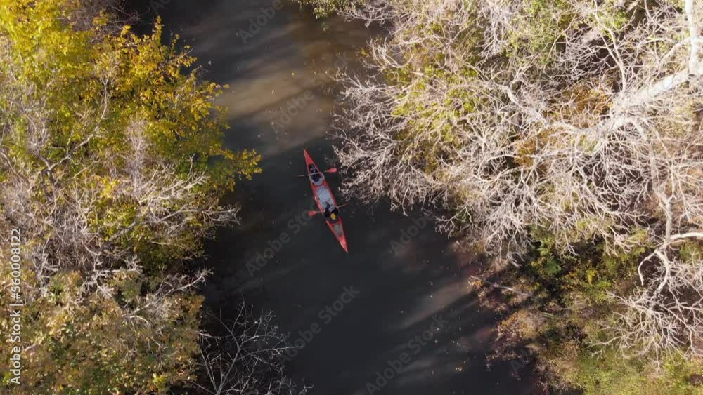 man and woman with canoe advance on the river in autumn, drone follows from the air Turkey iğneada man and woman with canoe advance on the river in autumn, drone follows from the air Turkey iğneada