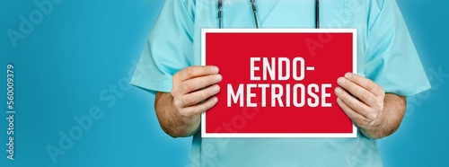 Endometriose. Arzt zeigt rotes Schild mit medizinischen Wort. Blauer Hintergrund. photo