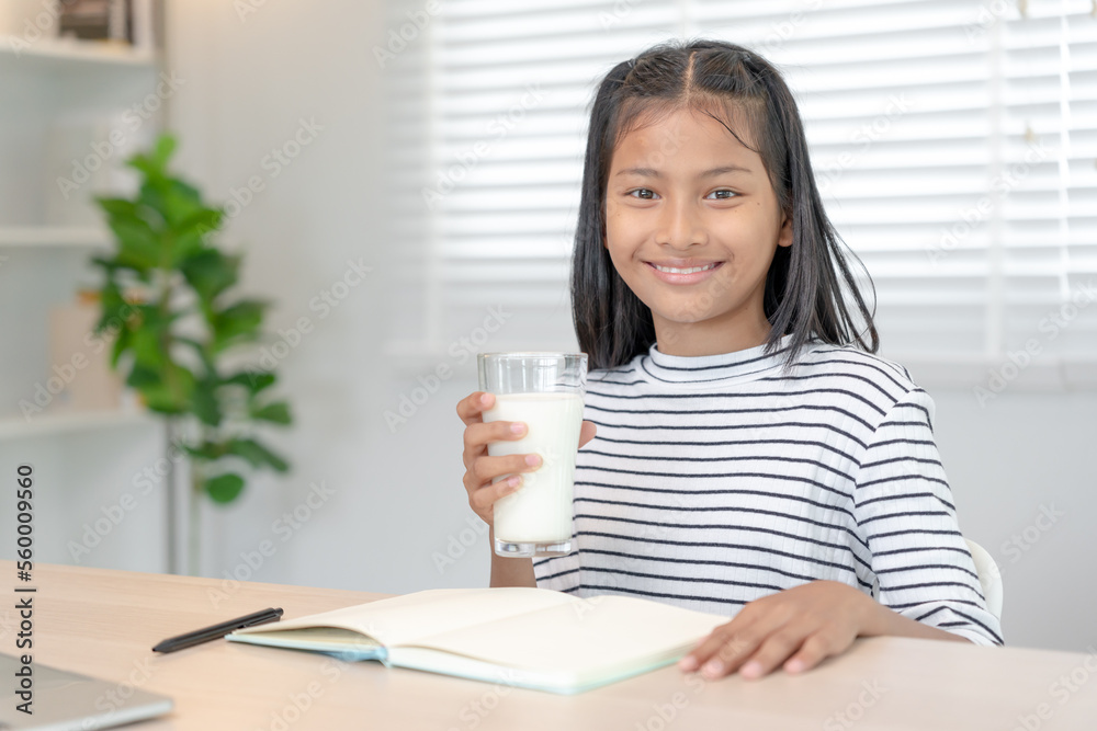 children women drink milk to nourish the body and nourish the brain. asian young little girl learn at home. girl happy drink milk and read a book for exam, Homeschool. education, vitamins, development children women drink milk to nourish the body and nourish the brain. asian young little girl learn at home. girl happy drink milk and read a book for exam, Homeschool. education, vitamins, development