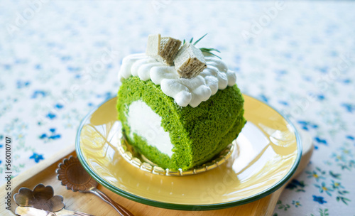 Matcha roll cake decorated with whipped cream on top soft light background  photo