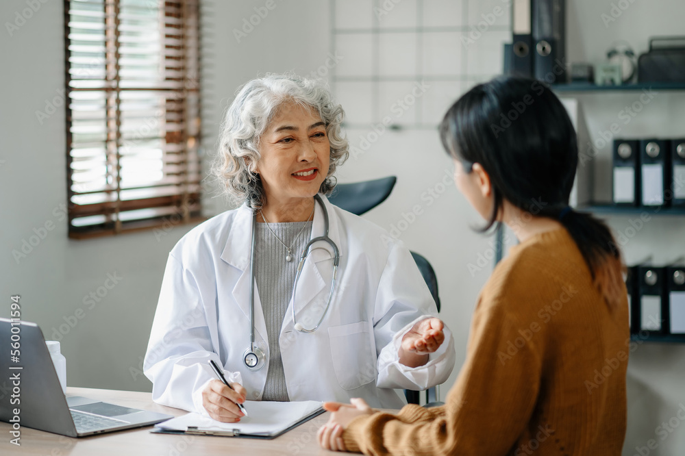 Doctor and patient discussing something while sitting at the table . Doctor and patient discussing something while sitting at the table .