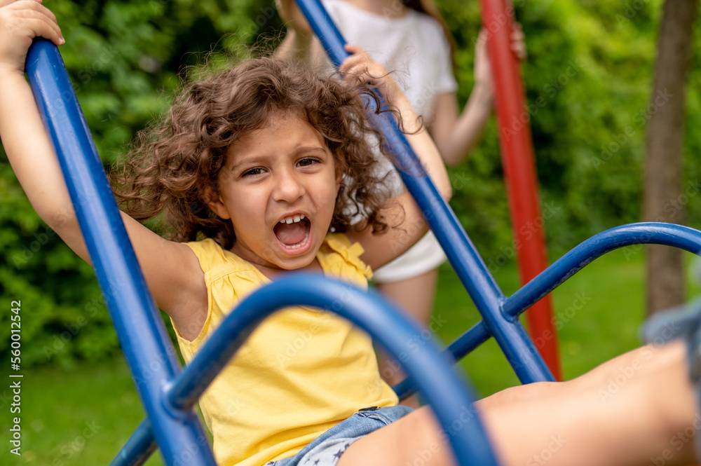 Cute girl on thw swing looking excited Cute girl on thw swing looking excited