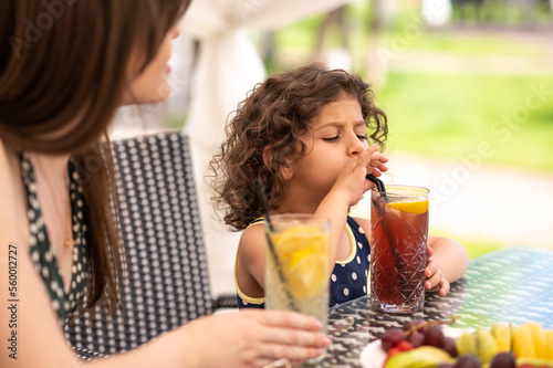 Mom and daughter having fruits and looking happy photo