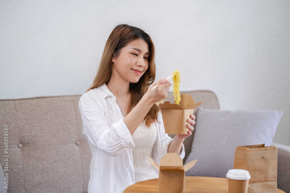 Asian woman with takeaway food and drinks at home. consumption eating home delivery food. enjoying delicious takeaway delivery tasty meal Asian woman with takeaway food and drinks at home. consumption eating home delivery food. enjoying delicious takeaway delivery tasty meal