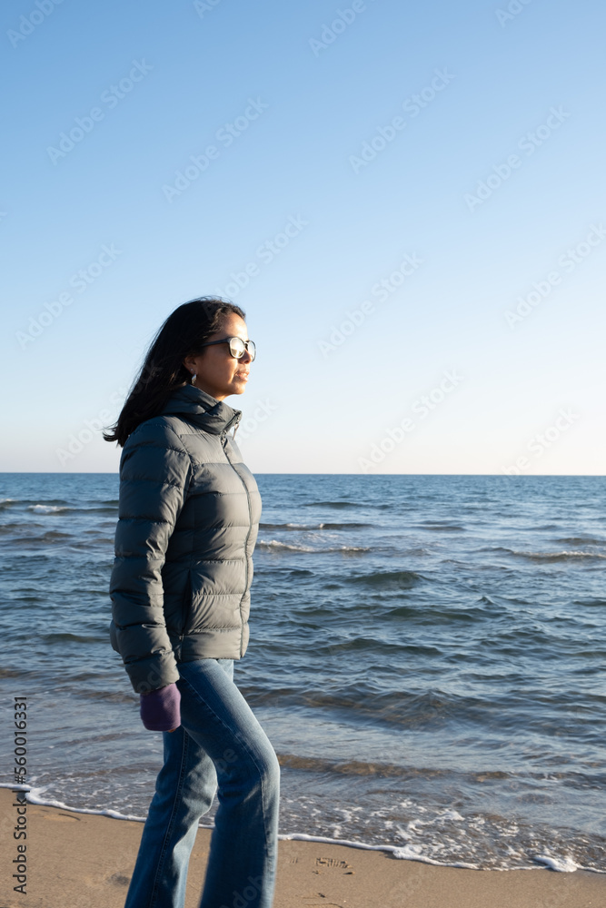 relaxed woman walking relaxing on the seashore in a sunny winter day 