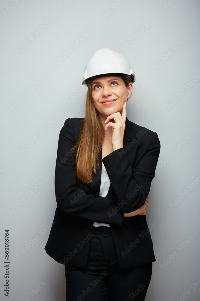 Woman engineer smiling and happy wearing safety helmet thinking and looking up. Woman engineer smiling and happy wearing safety helmet thinking and looking up.