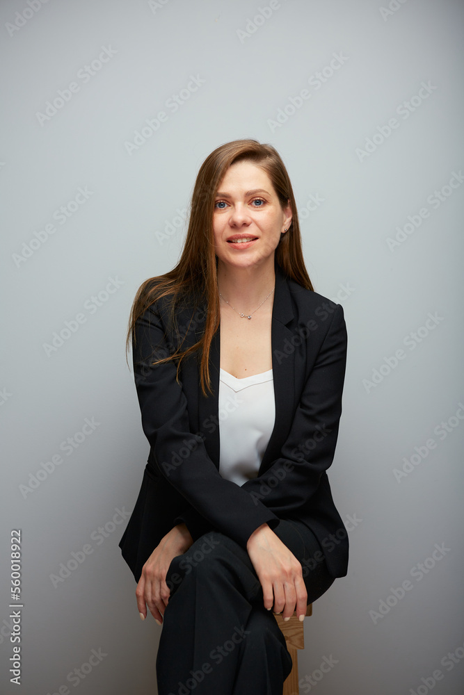Portrait of smiling woman in black business suit sitting on chair. Portrait of smiling woman in black business suit sitting on chair.