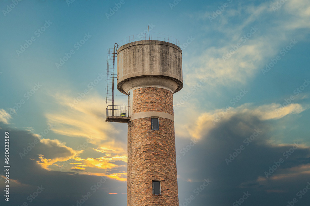 Old-fashioned water tower red brick water tower building blue sky and white clouds sunset sunset Old-fashioned water tower red brick water tower building blue sky and white clouds sunset sunset