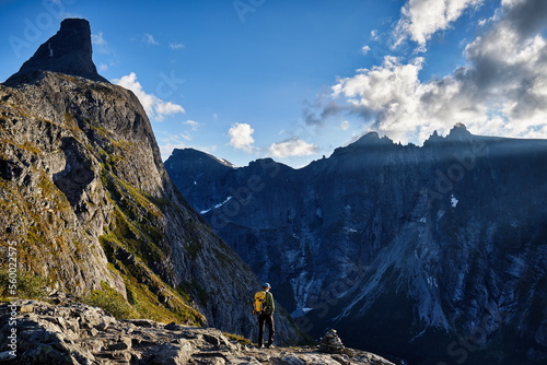 Mann, Bergsteiger, Bergwandern an Kante, Grat mit Aussicht auf Berge und Gipfel im Abendlicht photo