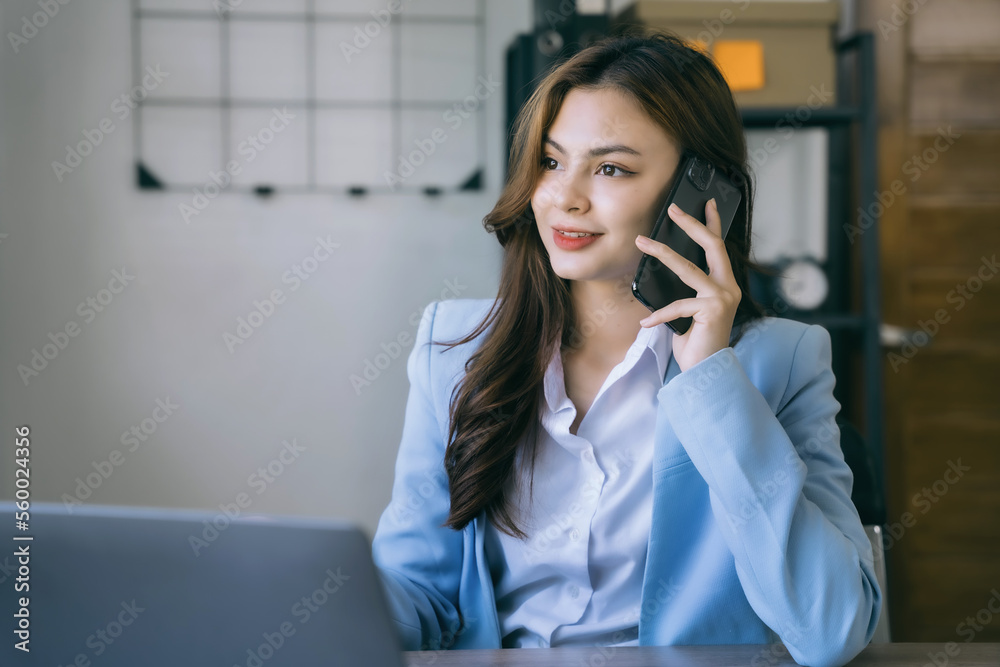 Asian business woman using mobile phone in office. Asian business woman using mobile phone in office.