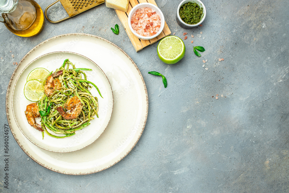 zucchini pasta with shrimps and pesto sauce. keto low carb diet. banner, menu, recipe place for text, top view zucchini pasta with shrimps and pesto sauce. keto low carb diet. banner, menu, recipe place for text, top view