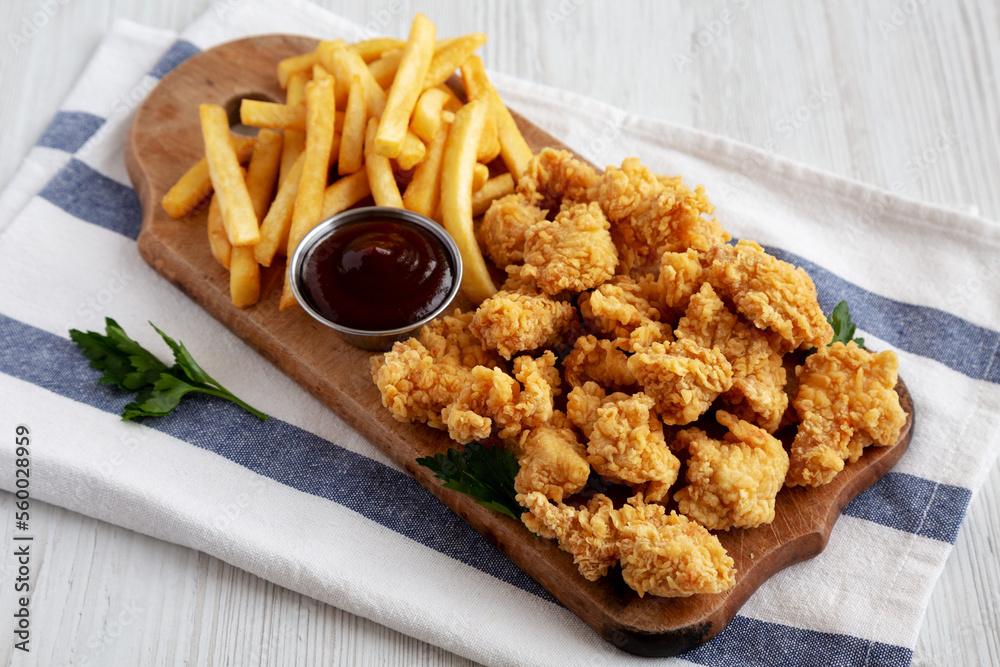 Homemade Popcorn Chicken with BBQ Sauce on a Rustic Wooden Board, side view. Homemade Popcorn Chicken with BBQ Sauce on a Rustic Wooden Board, side view.