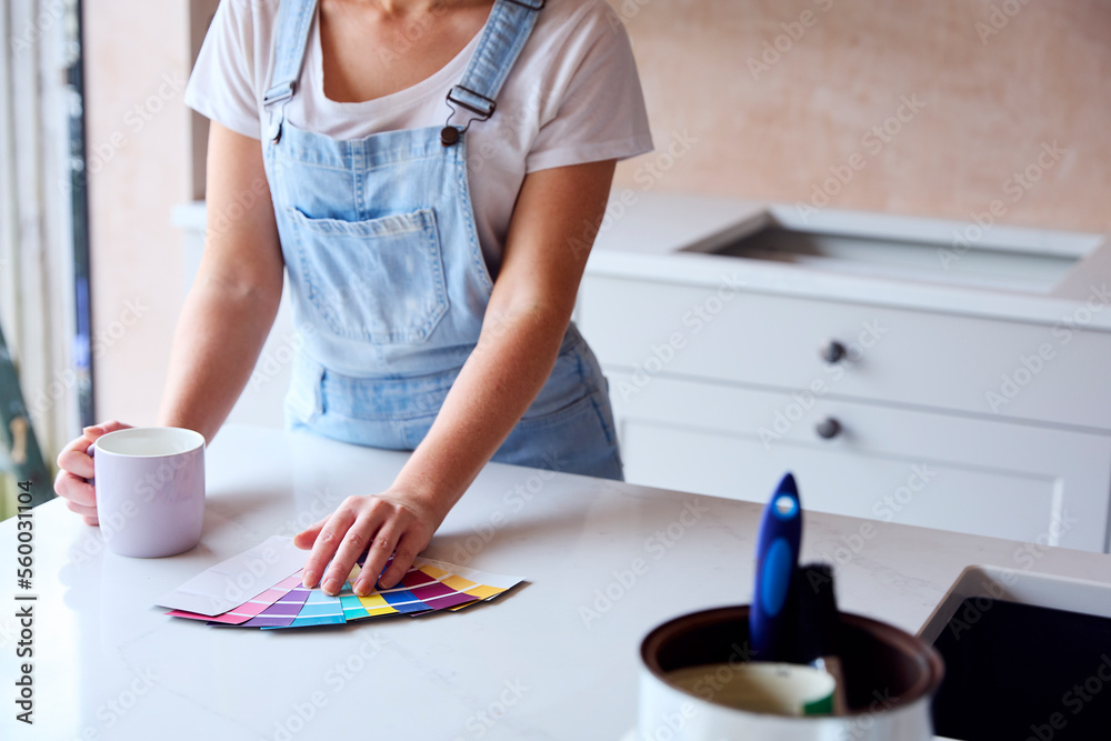 Close Up Of Woman Renovating Kitchen At Home Looking At Paint Swatches On Coffee Break Close Up Of Woman Renovating Kitchen At Home Looking At Paint Swatches On Coffee Break