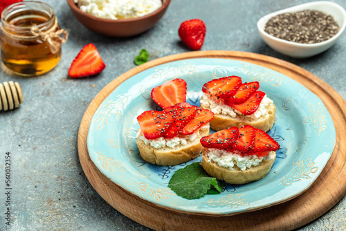 Crostini or toasts with strawberries and cream cheese ricotta. Delicious breakfast or snack, Clean eating, dieting, vegan food concept. top view