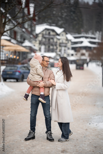 Wallpaper Mural Family with little girl are having fun on snowy winter day in small town of Czech republic Torontodigital.ca