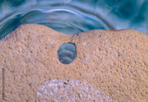 A sea pebble with a hole close-up.