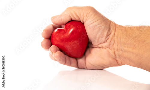 hand holding red heart from stone