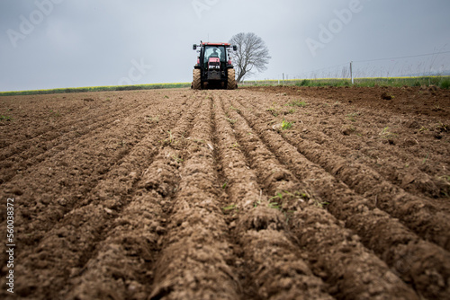 Fotobehang Un agriculteur dans son tracteur sème un champ d'orge.