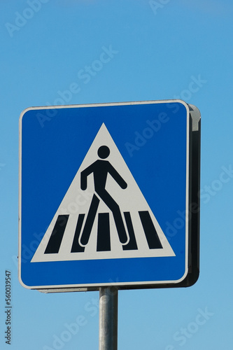 road sign pedestrian crossing close-up against the blue sky