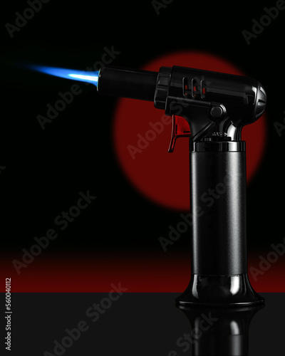 A gas blow torch kitchen with blue flame on the black background.