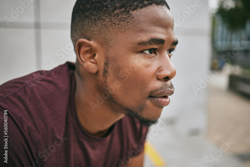 Face, fitness and exercise with a black man runner breathing alone outdoor in the city for cardio or endurance. Vision, motivation and workout with a male athlete training in an urban town for health